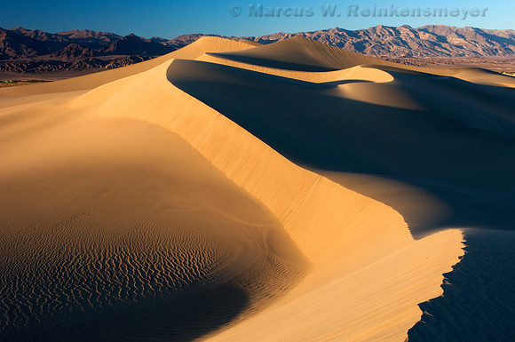 Dramatic sand dune formations flanked by the Panimint Mountains, at Mesquite Flat Dunes in Death Valley National Park.