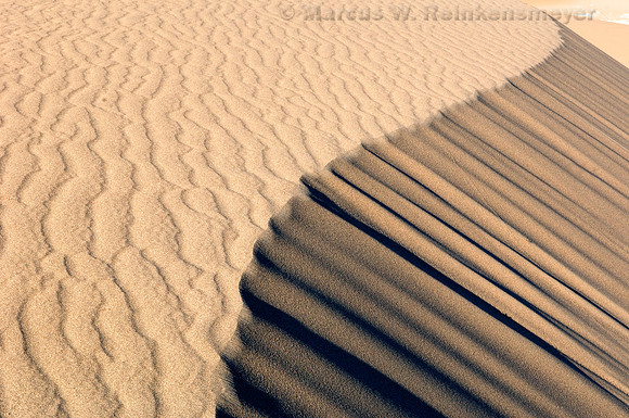 Ripples, blowouts and drifting sand accentuated by sunset shadows at Mesquite Flat Dunes, Death Valley National Park, California.