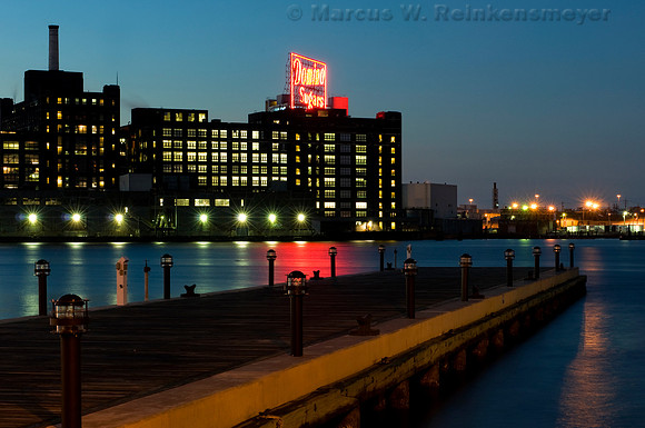 Domino Sugars building viewed from a waterfront pier in Baltimore, Maryland.