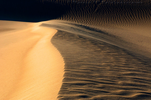 Ripples, blowouts and drifting sand accentuated by sunset shadows at Mesquite Flat Dunes, Death Valley National Park, California.