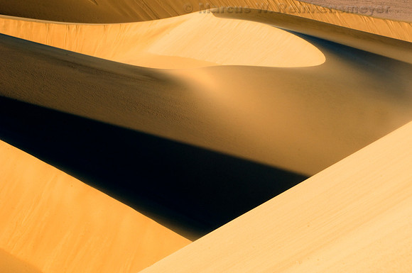 Ripples, blowouts and drifting sand accentuated by sunset shadows at Mesquite Flat Dunes, Death Valley National Park, California.