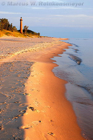 Illuminated by warm evening light, the Little Sable Point Lighthouse, located on the Lake Michigan shore at Silver Lake State Park, Michigan
