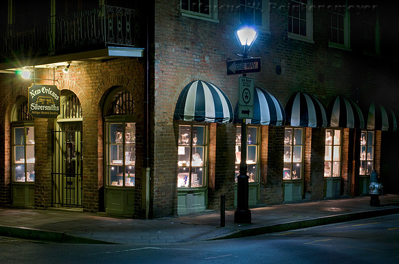 Night scene of Silversmiths storefront, located on one way street in New Orleans, Louisiana, displaying antique and modern jewelry.
