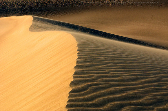 Ripples, blowouts and drifting sand accentuated by sunset shadows at Mesquite Flat Dunes, Death Valley National Park, California.