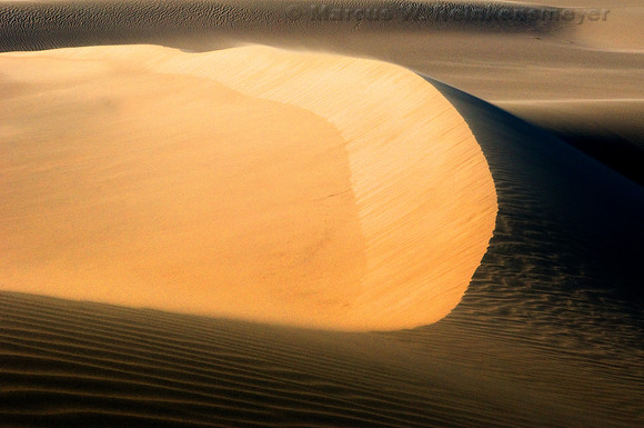 Ripples, blowouts and drifting sand accentuated by sunset shadows at Mesquite Flat Dunes, Death Valley National Park, California.