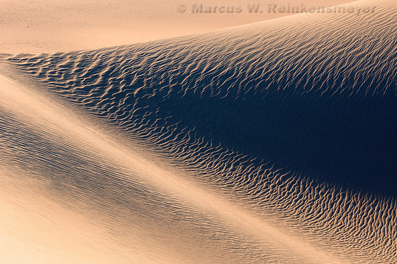Warm sunlight and long shadows create abstract images at the Mesquite Flat Dunes in Death Valley National Park, California.