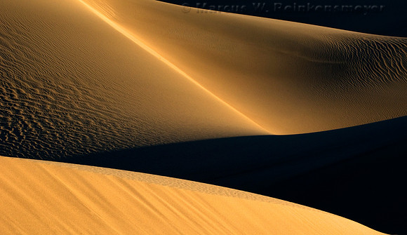 Warm sunlight and long shadows create abstract images at the Mesquite Flat Dunes in Death Valley National Park, California.